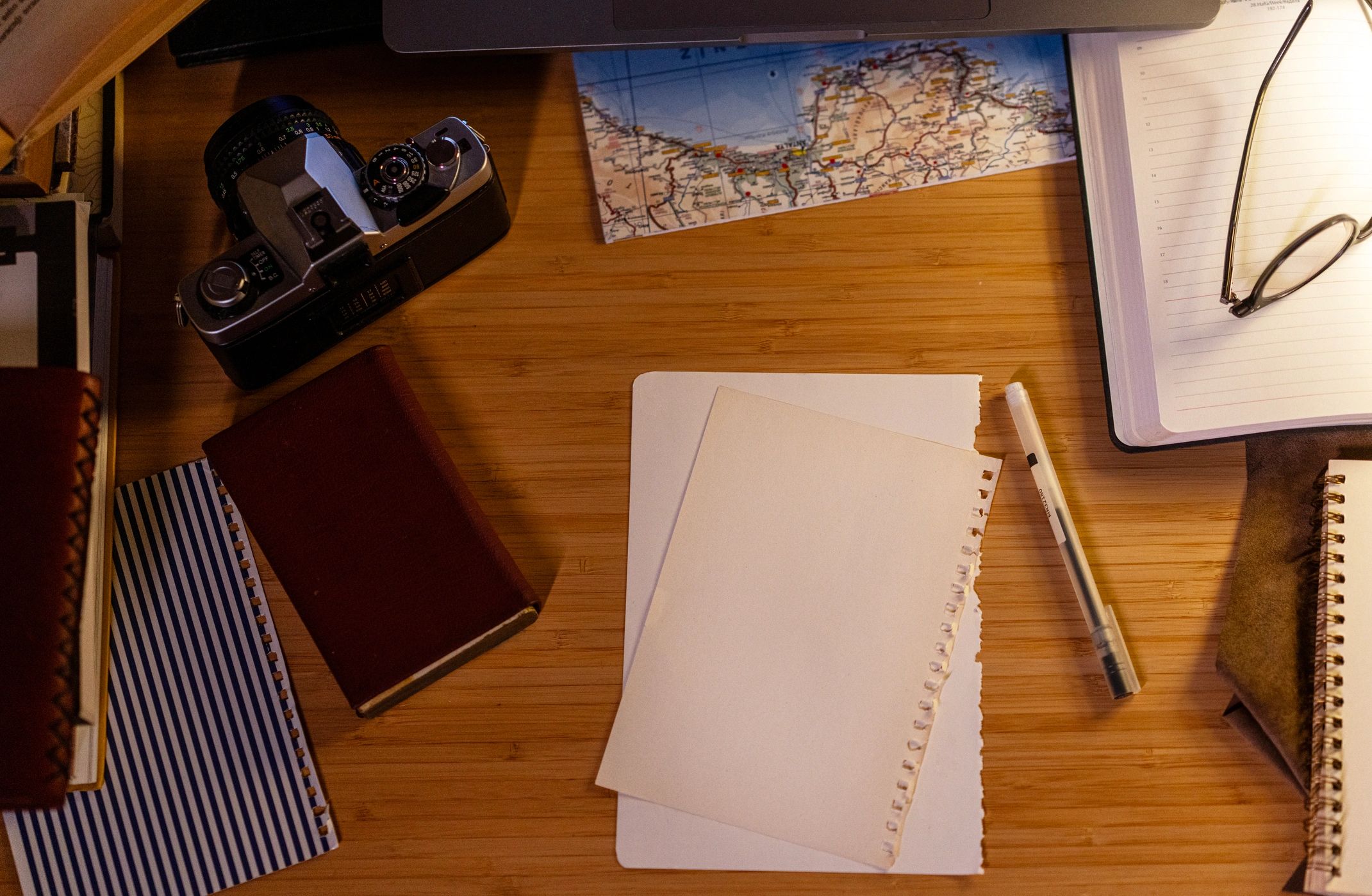 Writer's desk with map, camera, and creative materials